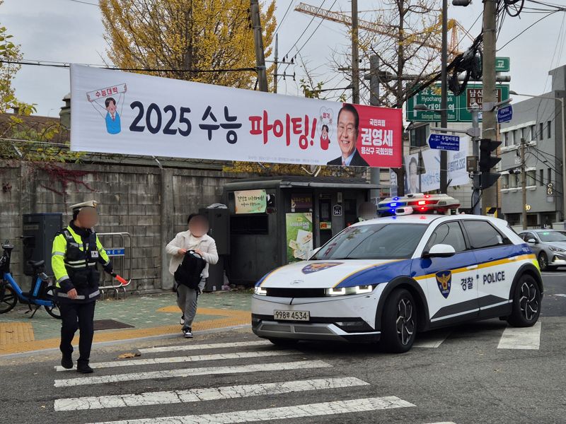 14일 수능 시험장인 서울 용산고 앞에서 한 수험생이 경찰차에서 내려 시험장으로 뛰어가고 있다. 사진=장유하 기자