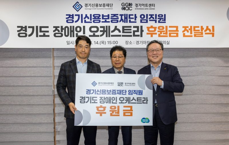 시석중 경기신보 이사장(오른쪽)이 서춘기 경기아트센터 사장(가운데)에게 후원금을 전달하고 있다. 경기신보 제공