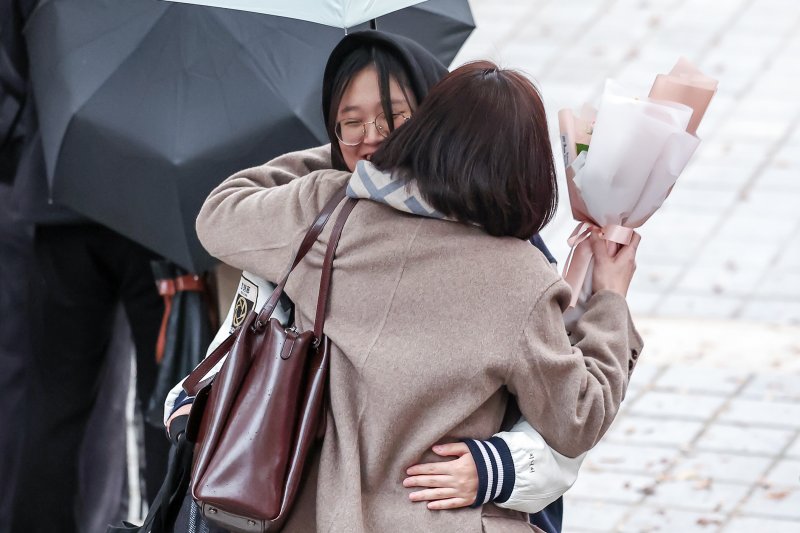 14일 오후 서울 종로구 덕성여자고등학교에서 시험을 마친 수험생들이 고사장을 나서며 부모님과 포옹하고 있다. 뉴스1