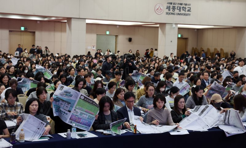 15일 서울 광진구 세종대학교에서 열린 종로학원 2025 정시 합격점수 예측 및 전략 설명회에서 학부모들이 정시모집 배치 참고표를 보며 설명을 듣고 있다. 2024.11.15/뉴스1 ⓒ News1 김명섭 기자