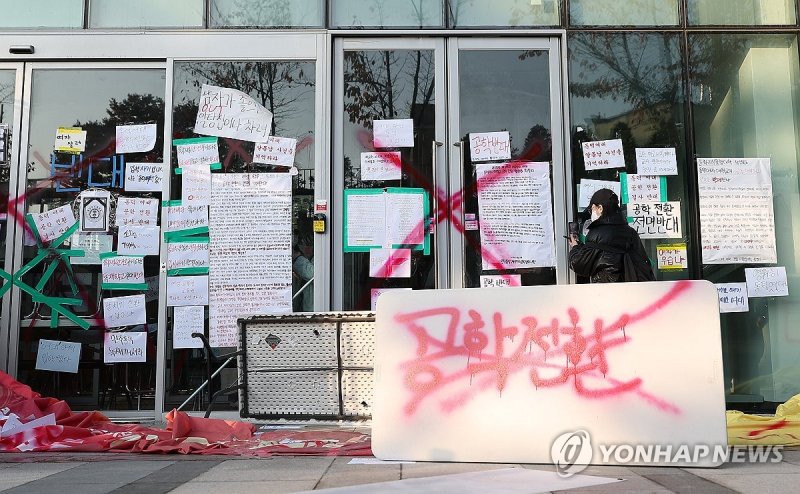 동덕여자대학교의 남녀공학 전환 추진 논의에 반발한 학생들이 지난 12일 오전 서울 성북구 동덕여대 본관에서 항의하며 건물 안쪽에서 문을 막고 서 있다. 학교 측은 남녀공학 전환에 대해 확정된 사안이 아니라는 입장을 밝혔다. 사진=연합뉴스