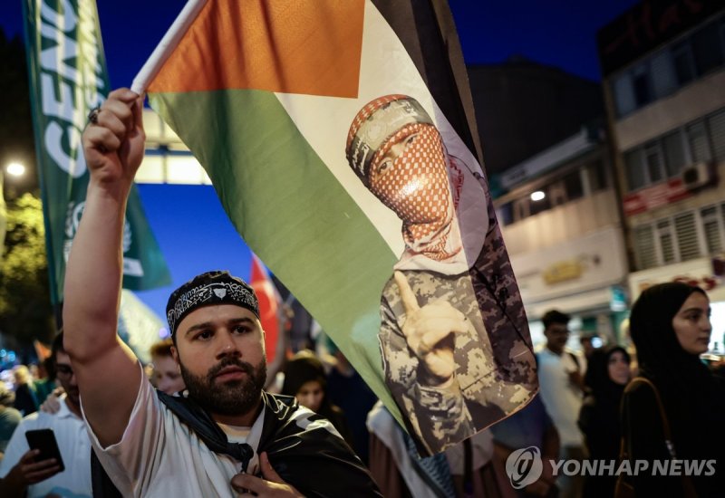 튀르키예 이스탄불의 친팔레스타인 시위대 epa11513848 A pro-Palestinian protester holds a Palestine flag and shouts slogans during a protest after evening pray to condemn the killing of Hamas leader Ismail Haniyeh, in Istanbul, Turkey, 31 July 2024. According to an Iranian Revolutionary Guard Corps (IRGC) statement on 