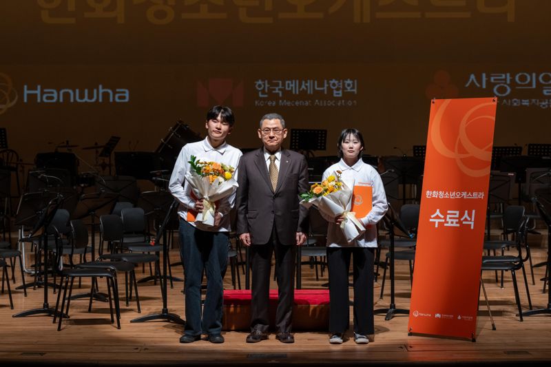 김신연 한화사회봉사단장(사장)이 지난 19일 천안 성환문화회관에서 열린 '한화청소년오케스트라 2024 정기연주회'에서 대표 학생들에게 꽃다발을 전달한 뒤 기념촬영을 하고 있다. 한화그룹 제공