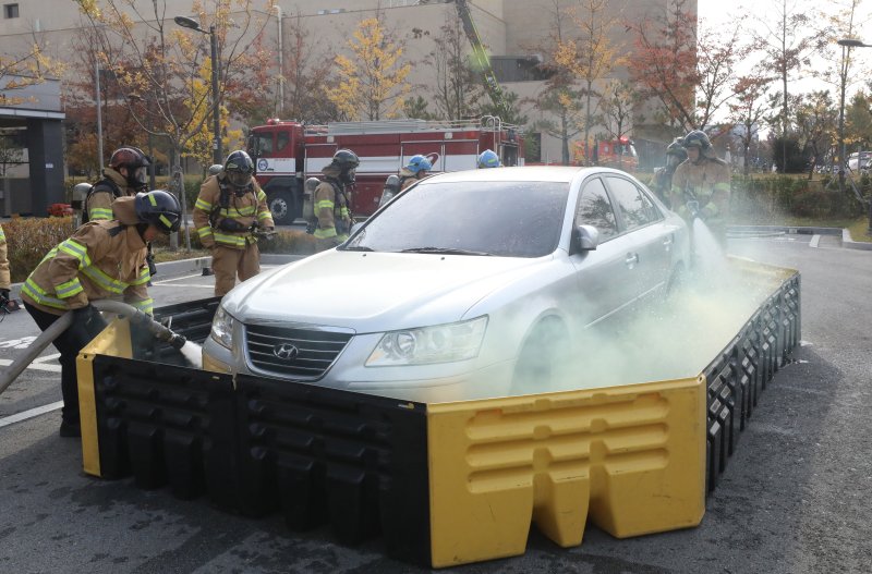 20일 전주시 덕진구 팔복LH아파트 및 더 메이호텔에서 행정안전부를 비롯한 전북소방본부, LH 등이 참여한 가운데 열린 유관기관합동 전기차 화재 대응 제4차 READY Korea 훈련에서 소방대원들이 화재 진압한 전기차를 이동식 소화수조로 이동한 뒤 물을 채우고 있다. 2024.11.20/뉴스1 ⓒ News1 김기남 기자