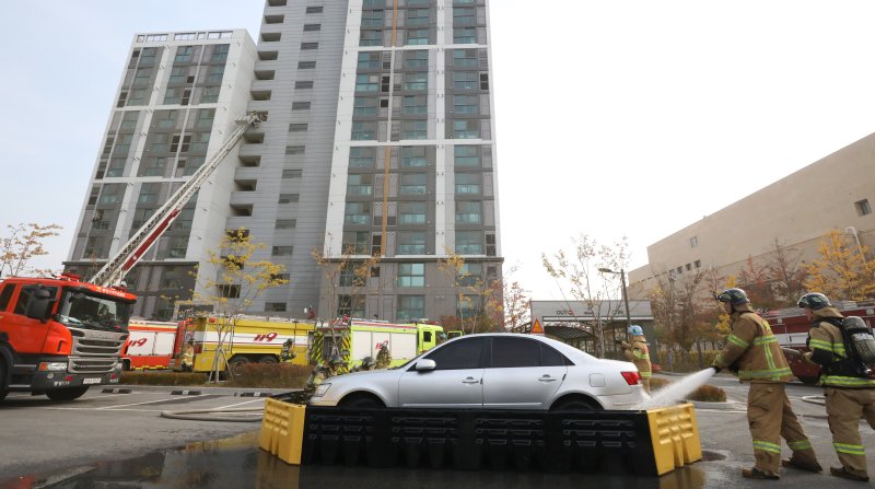 20일 전주시 덕진구 팔복LH아파트 및 더 메이호텔에서 행정안전부를 비롯한 전북소방본부, LH 등이 참여한 가운데 열린 유관기관합동 전기차 화재 대응 제4차 READY Korea 훈련에서 소방대원들이 화재 진압한 전기차를 이동식 소화수조로 이동한 뒤 물을 채우고 있다. 2024.11.20/뉴스1 ⓒ News1 김기남 기자