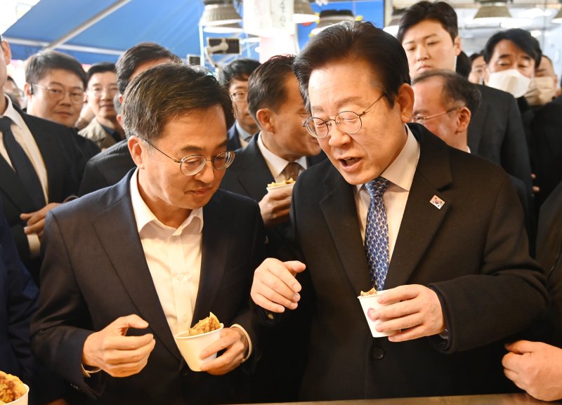이재명 더불어민주당 대표와 김동연 경기도지사가 21일 경기도 수원시 못골시장을 방문해 호떡을 시식하며 대화하고 있다. 뉴시스