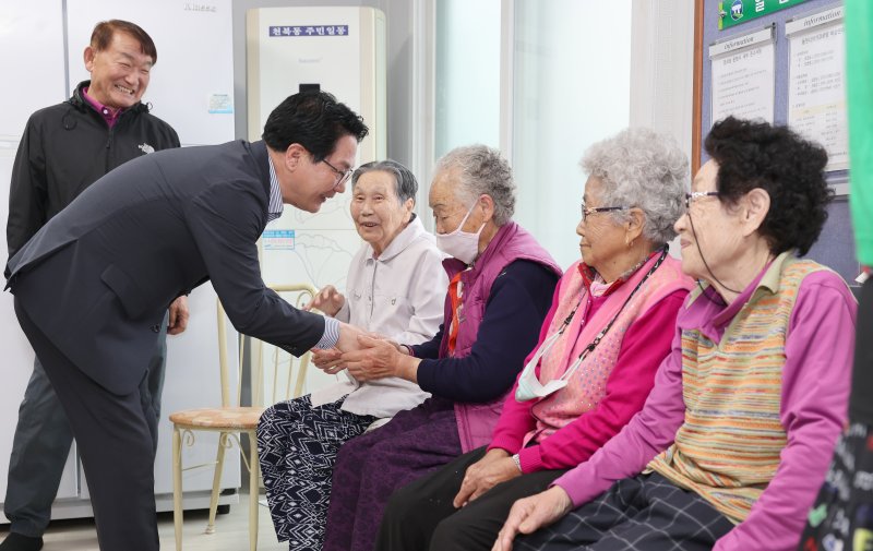 심덕섭 전북 고창군수(왼쪽)가 경로당을 찾아 인사를 나누는 모습. 고창군 제공