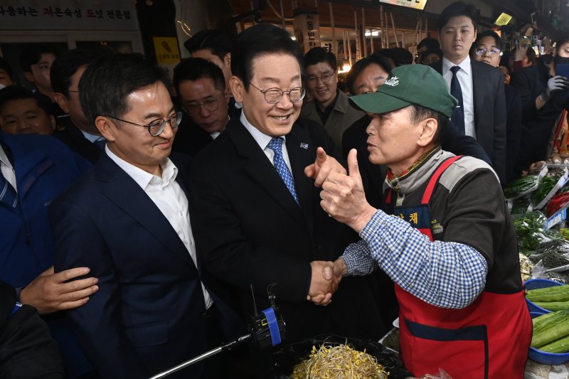 이재명 더불어민주당 대표(가운데)와 김동연 경기도지사(왼쪽 첫번째)가 21일 오전 경기 수원시 팔달구 못골시장을 찾아 소상공인들과 인사를 나누고 있다. 연합뉴스