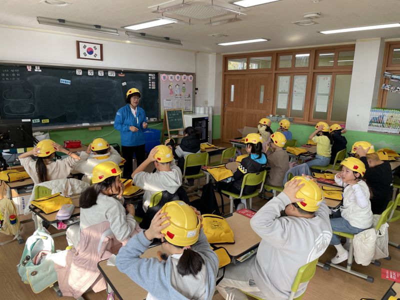 지난 21일 울진 죽변초등학교에서 ‘재난안전 경안전모 전달식 및 재난안전교육’ 행사를 진행하고 있다. 울진 죽변초등학교 학생들이 어린이용 경안전모를 착용하고 안전 교육을 받고 있다. 현대건설 제공