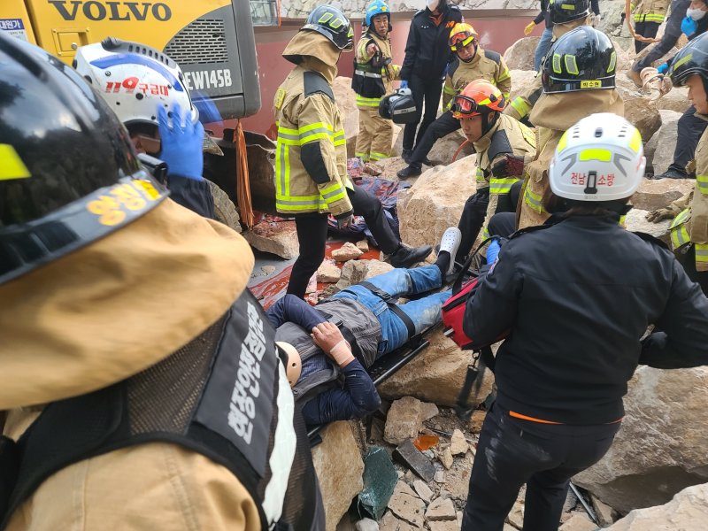 23일 오후 4시 22분쯤 전남 여수시 신덕동의 한 야적장 공사 현장에서 석축 작업을 하고 있던 포클레인이 넘어져 작업자들이 깔리는 사고가 발생했다. 사진은 소방당국이 구조하는 모습.(전남 여수소방서 제공) 2024.11.23/뉴스1