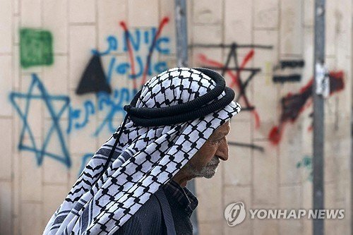 유대인 정착촌 근처 이스라엘군 초소 지나는 팔레스타인 노인 (출처=연합뉴스)