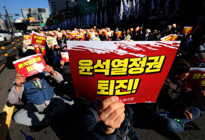 [서울=뉴시스] 김명년 기자 = 전국택배노동조합 조합원들이 24일 오후 서울 중구 서울역 4번출구 앞에서 전국택배노동자대회를 열고 구호를 외치고 있다. 2024.11.24. kmn@newsis.com