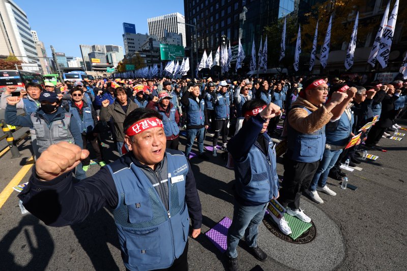 [서울=뉴시스] 김명년 기자 = 전국택배노동조합 조합원들이 24일 오후 서울 중구 서울역 4번출구 앞에서 전국택배노동자대회를 열고 구호를 외치고 있다. 2024.11.24. kmn@newsis.com