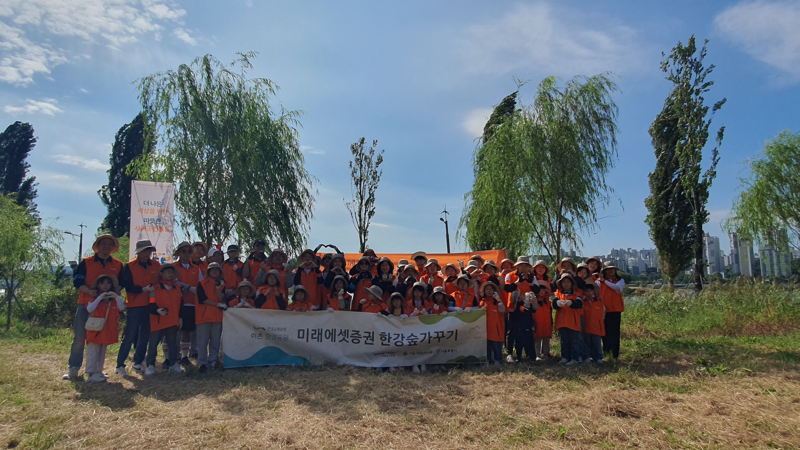 미래에셋증권 임직원 및 가족들이 지난 9월 28일 서울 용산구 이촌 한강공원 미래에셋증권 숲에서 진행한 '미래에셋증권 숲 가꾸기' 행사에서 기념 촬영을 하고 있다. 미래에셋증권 제공