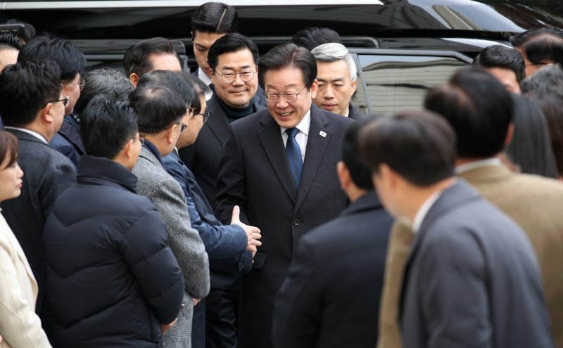 이재명 더불어민주당 대표가 25일 서울 서초구 중앙지방법원에서 열린 위증교사 사건 1심 선고 공판에 출석하며 민주당 의원들과 인사하고 있다. 뉴시스