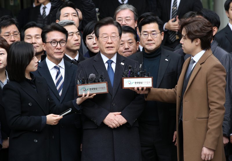 이재명 더불어민주당 대표(앞줄 오른쪽 세번째)가 25일 오후 서울 서초구 서울중앙지법에서 열린 '위증교사' 혐의사건 1심 선고 공판에서 무죄선고를 받은 뒤 취재진에게 소감을 밝히고 있다. 연합뉴스