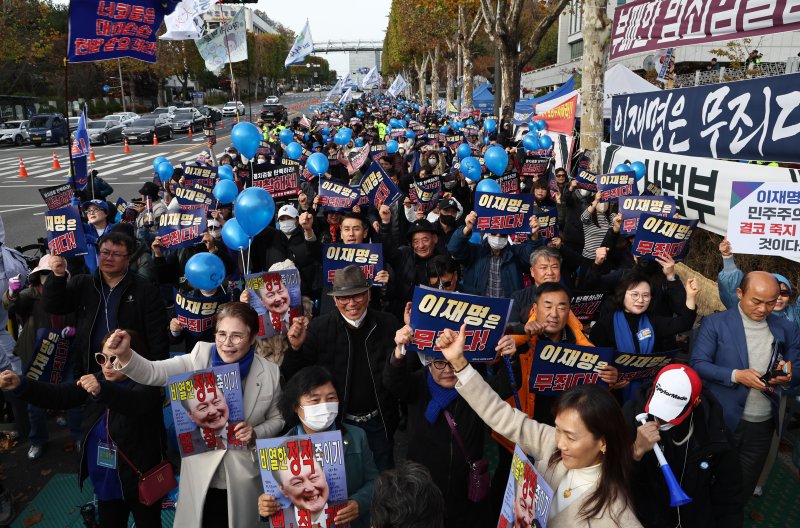 25일 오후 서울중앙지법에서 열린 더불어민주당 이재명 대표의 '위증교사 혐의' 사건 1심 선고가 무죄 판결되자 서울중앙지검 인근에서 지지자들이 기뻐하고 있다. 연합뉴스