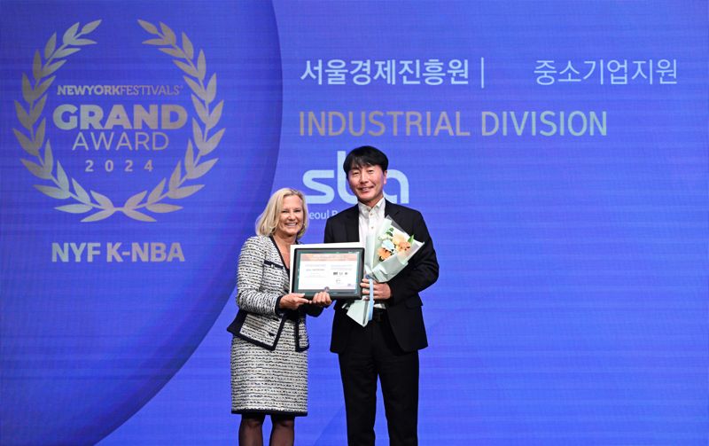 김현우 서울경제진흥원(SBA) 대표(오른쪽)가 2024 뉴욕페스티벌에서 엘렌스미스로부터 대한민국 국가브랜드대상 '한국산업의 공공 브랜드' 중소기업지원 부문 최고 브랜드 상패를 받고 기념촬영을 하고 있다. SBA 제공