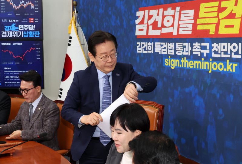 [서울=뉴시스] 조성우 기자 = 이재명(왼쪽 두 번째) 더불어민주당 대표가 27일 오전 서울 여의도 국회에서 열린 최고위원회의가 끝난 뒤 시계를 보며 자리를 나서고 있다. 2024.11.27. xconfind@newsis.com