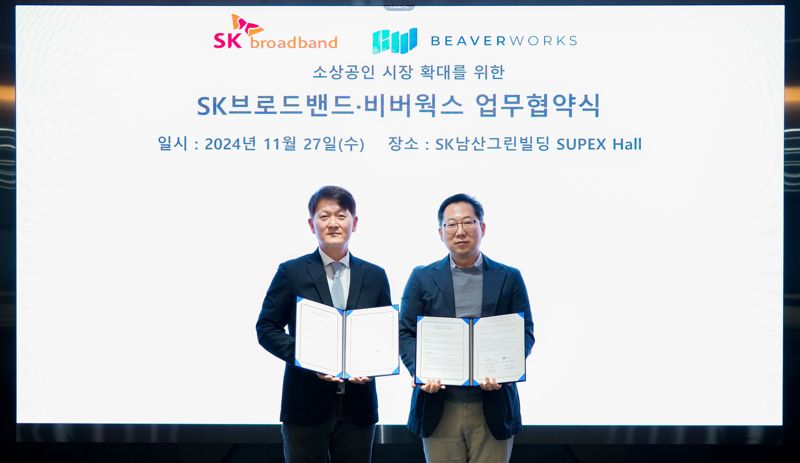 SK브로드밴드 송정범 SOHO&SE 담당(왼쪽)과 비버웍스 김종윤 대표가 27일 서울 중구 SK브로드밴드 본사에서 업무 협약을 체결한 후 기념촬영을 하고 있다. SK브로드밴드 제공