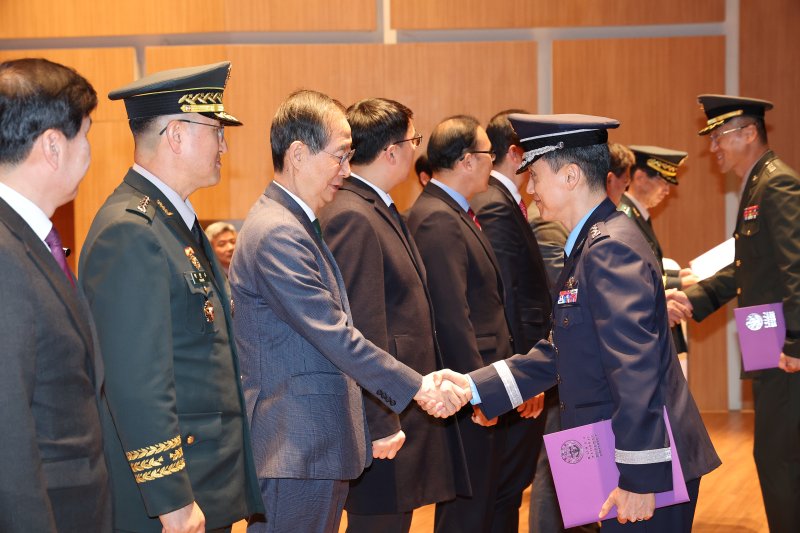 한덕수 국무총리가 28일 오전 충남 논산시 국방대학교 컨벤션센터에서 열린 국방대학교 안보과정 졸업식에서 졸업증서를 받은 졸업생 대표를 격려하고 있다. 이날 졸업식에서는 육-해-공군-해병대 대령 이상 현역 간부와 고위 공무원, 공공기관 임원, 언론인 등 220명이 졸업증서를 받았다. 사진=연합뉴스