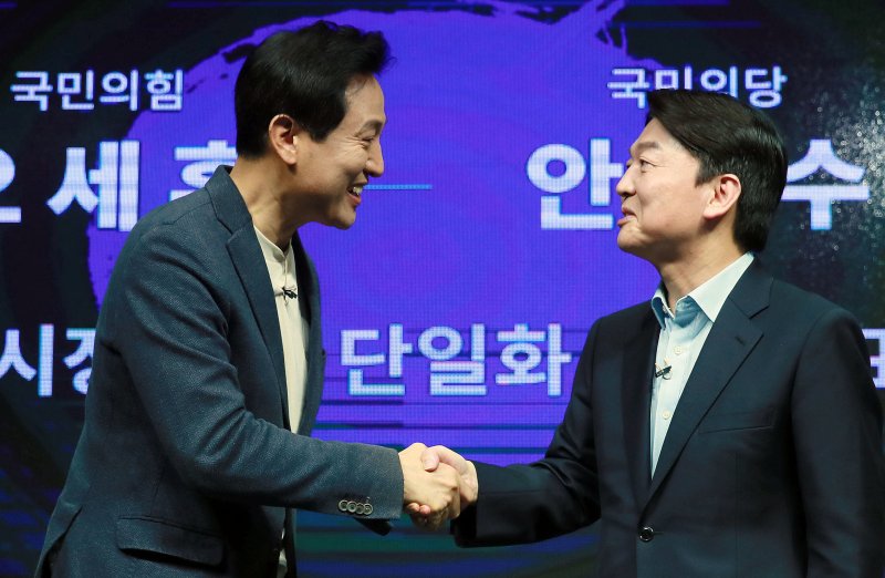 안철수 국민의당 서울시장 후보가 2021년 3월 19일 오전 긴급회견을 갖고 국민의힘 김종인·오세훈 단일화방식을 전격 수용하기로 결정했다. 사진은 오 후보(왼쪽)와 안 후보가 지난 15일 서울 영등포 더플러스 스튜디오에서 열린 단일화 비전발표회를 마친 후 악수하고 있는 모습. 2021.3.19/뉴스1 ⓒ News1 국회사진취재단