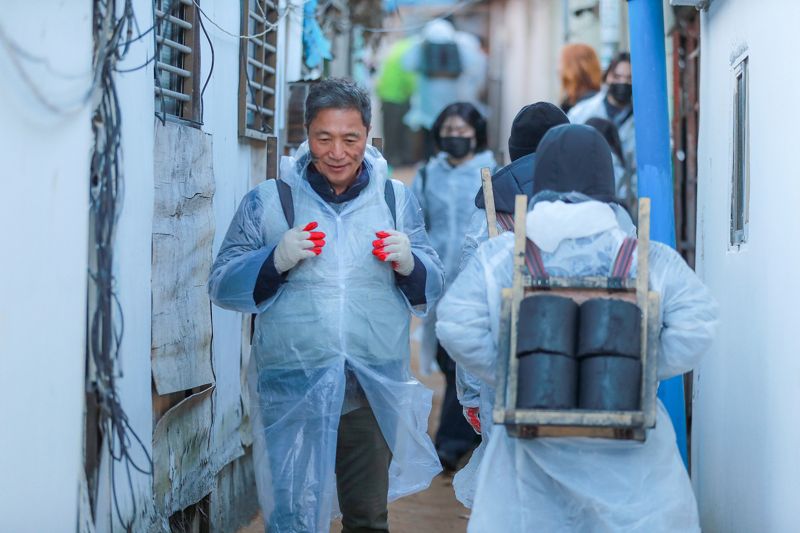 이학재 인천국제공항공사 사장(앞줄 왼쪽)이 지난 3일 인천 학익동에서 진행된 '함께하는 따뜻한 마음, 연탄 나눔' 봉사활동에서 봉사자들과 산동네 이웃에게 연탄을 배달하고 있다. 인천국제공항공사 제공