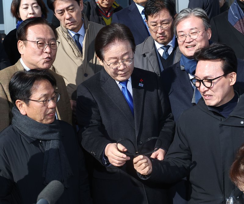 계엄군 수갑 살펴보는 李대표. 이재명 더불어민주당 대표(가운데)가 4일 조국혁신당 등 야 5당이 국회 본청 앞 계단에서 공동 개최한 '윤석열 대통령 사퇴 촉구·탄핵 추진 비상시국대회'에서 계엄군이 놓고 간 수갑을 살펴보고 있다. 연합뉴스