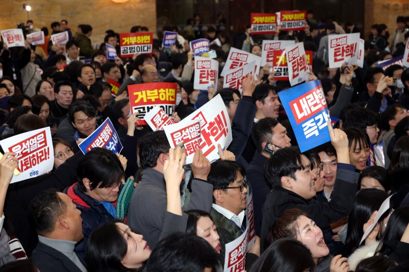 7일 오후 서울 여의도 국회 본회의장 입구에서 야당 보좌진들이 손피켓을 들고 '윤석열 대통령 탄핵' 구호를 외치고 있다. 사진=뉴시스