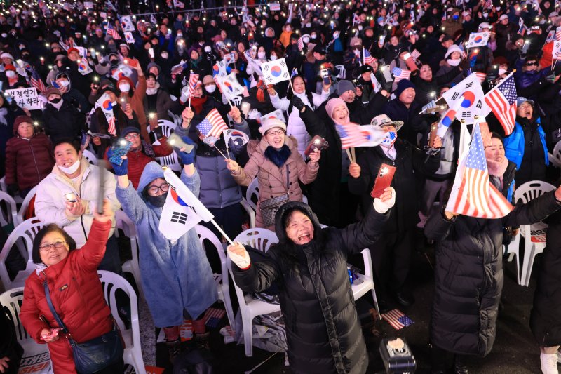 7일 서울 광화문 동화면세점 앞에서 대한민국바로세우기국민운동본부 주최로 열린 '자유 대한민국 수호 광화문 국민혁명대회' 참가자들이 김건희 여사 특검법 부결과 대통령 탄핵소추안에 관한 소식을 듣고 기뻐하고 있다. 2024.12.7