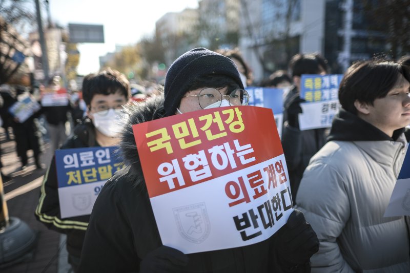 지난 8일 서울 종로구 대학로에서 열린 서울대병원 전공의협의회 비상대책위원회 ‘젊은 의사 의료계엄 규탄 집회’에서 사직 전공의를 비롯한 젊은 의사들이 피켓을 들고 있다. 뉴시스