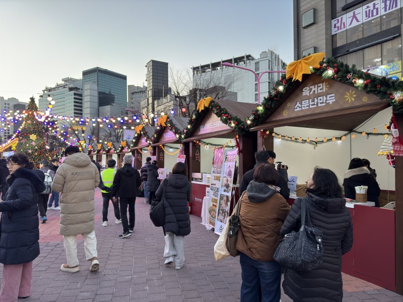 지난 6일 홍대 레드로드에서 열린 '12월 동행축제' 참여 부스 앞을 방문객들이 지나가고 있다.