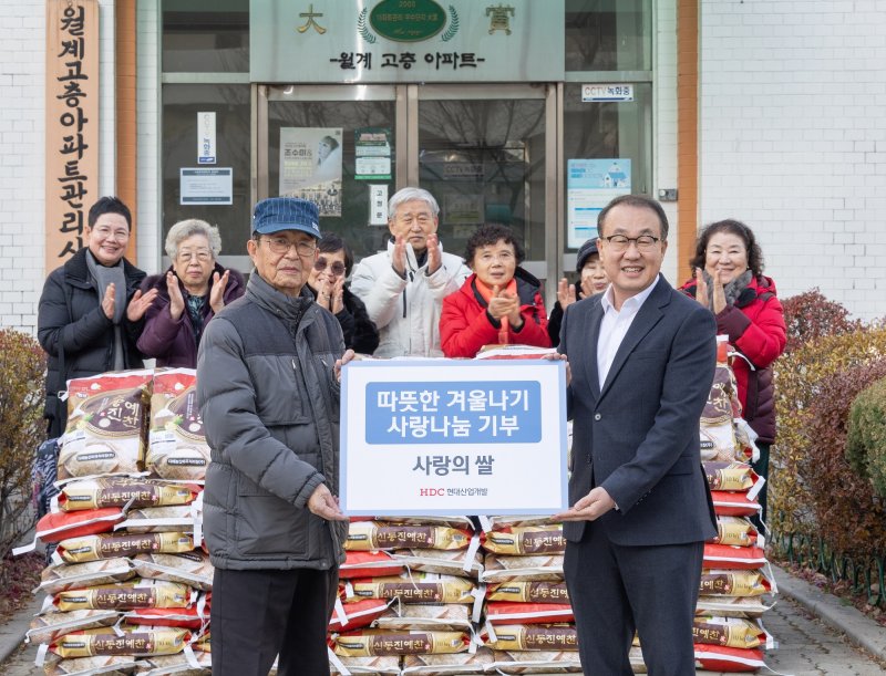 신왕섭 HDC현대산업개발 실장(앞줄 오른쪽)이 지난 9일 서울 노원구 월계시영 아파트에서 열린 쌀 전달식에서 기념촬영을 하고 있다. HDC현대산업개발 제공