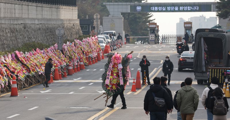 11일 오후 서울 용산구 대통령실 출입문 앞 도로에서 화환 업체 관계자가 윤석열 대통령 지지자들이 보낸 화환을 옮기고 있다. /사진=뉴스1