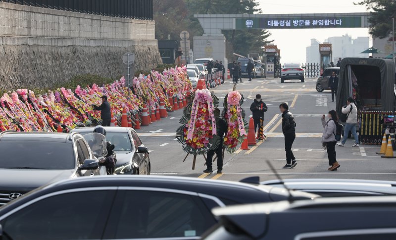 11일 오후 서울 용산구 대통령실 출입문 앞 도로에서 화환 업체 관계자가 윤석열 대통령 지지자들이 보낸 화환을 옮기고 있다. /사진=뉴스1