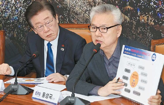 비상경제점검회의 하는 민주 이재명 더불어민주당 대표(왼쪽)가 11일 여의도 국회에서 열린 비상경제점검회의에서 홍성국 당 국가경제자문회의 의장이 들고 있는 경제상황 관련 자료를 보고 있다. 연합뉴스