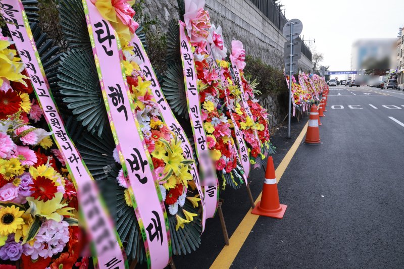 대통령실 앞에 늘어선 '탄핵 반대' 화환 11일 서울 용산 대통령실 청사 입구 부근에 윤석열 대통령 지지자들이 가져다 놓은 '탄핵 반대' 화환이 놓여 있다. 연합뉴스