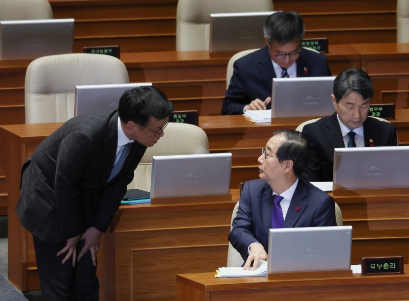 한덕수 국무총리가 13일 오후 국회 본회의에서 열린 '윤석열 대통령 위헌적 비상계엄 선포 내란행위 관련 긴급현안질문'에 참석해 최상목 부총리 겸 기획재정부 장관과 대화하고 있다. 연합뉴스