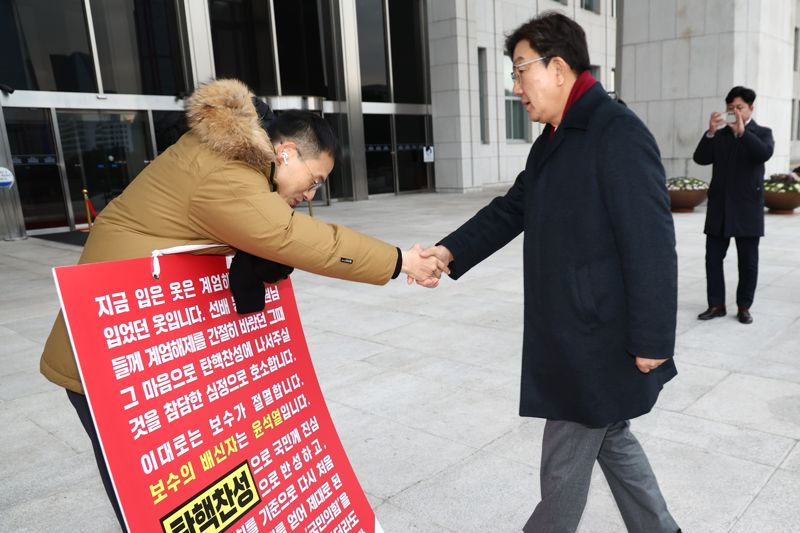 김상욱 국민의힘 의원이 13일 오전 서울 여의도 국회 본청 앞에서 윤석열 대통령 탄핵 찬성 호소 1인 시위 중 만난 권성동 원내대표와 인사하고 있다. 사진=뉴스1