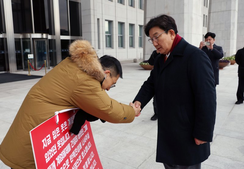 [서울=뉴시스] 고승민 기자 = 권성동 국민의힘 원내대표가 13일 서울 여의도 국회에서 윤석열 대통령의 탄핵을 촉구하며 1인시위 중인 김상욱 의원과 악수하고 있다. 2024.12.13. kkssmm99@newsis.com