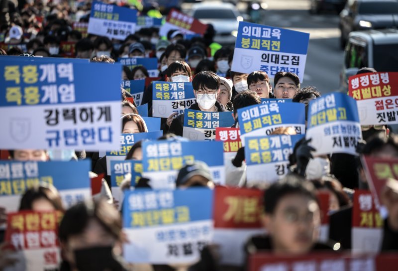 [서울=뉴시스] 정병혁 기자 = 지난 8일 서울 종로구 대학로에서 열린 서울대병원 전공의협의회 비상대책위원회 ‘젊은 의사 의료계엄 규탄 집회’에서 사직 전공의를 비롯한 젊은 의사들이 피켓을 들고 있는 모습. 2024.12.08. jhope@newsis.com