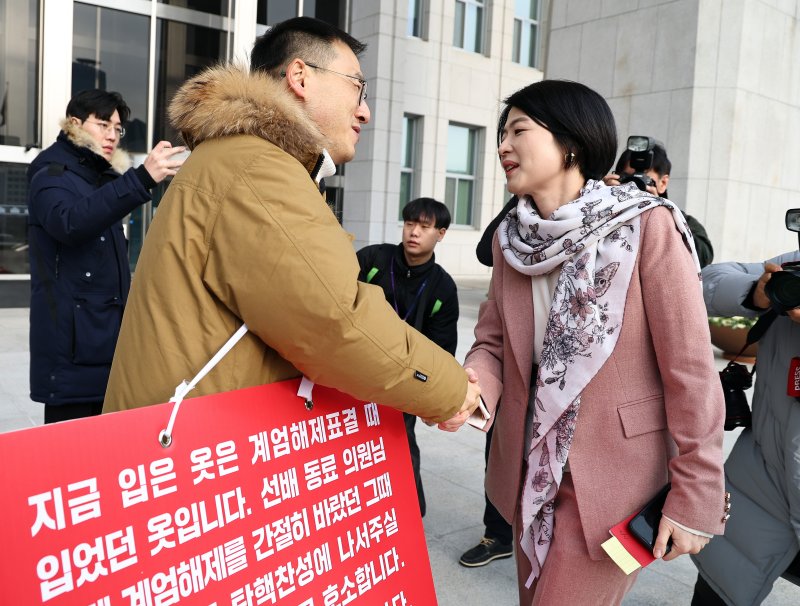 김상욱 국민의힘 의원이 13일 오전 서울 여의도 국회 본청 앞에서 윤석열 대통령 탄핵 표결 찬성을 호소하던 중 한지아 국민의힘 의원과 인사 나누고 있다. 2024.12.13/뉴스1 ⓒ News1 구윤성 기자