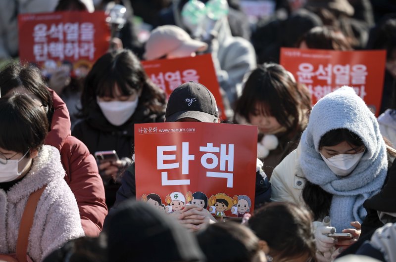 [서울=뉴시스] 정병혁 기자 = 14일 서울 영등포구 국회 앞에서 열린 '내란수괴 윤석열 즉각탄핵' 범국민 촛불대행진에 참가한 시민들이 피켓을 들고 있다. 2024.12.14. jhope@newsis.com