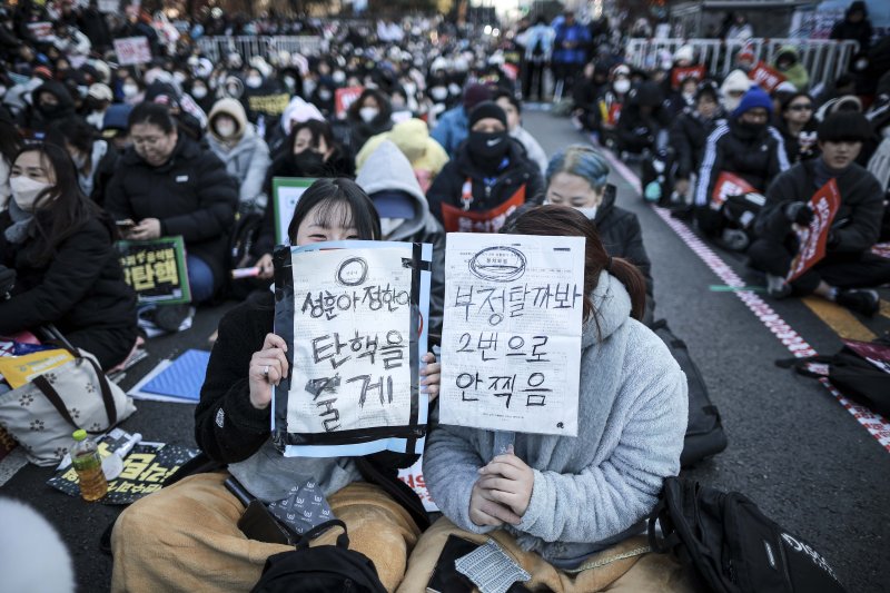 [서울=뉴시스] 정병혁 기자 = 14일 서울 영등포구 국회 앞에서 열린 '내란수괴 윤석열 즉각탄핵' 범국민 촛불대행진에 참가한 시민들이 피켓을 들고 있다. 2024.12.14. jhope@newsis.com