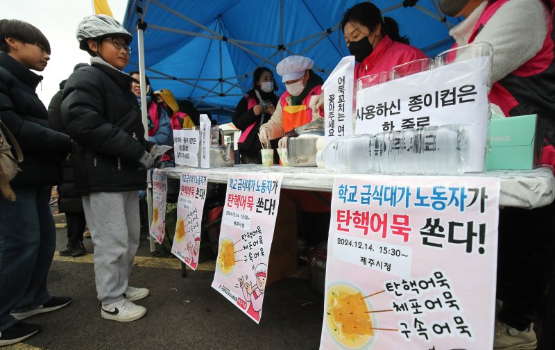 [제주=뉴시스] 우장호 기자 = 윤석열 대통령 탄핵소추안 재표결이 이뤄지는 14일 오후 제주시청 주차장 인근에서 학교 급식대 노동자들이 시민들에게 어묵을 나눠주고 있다. 2024.12.14. woo1223@newsis.com