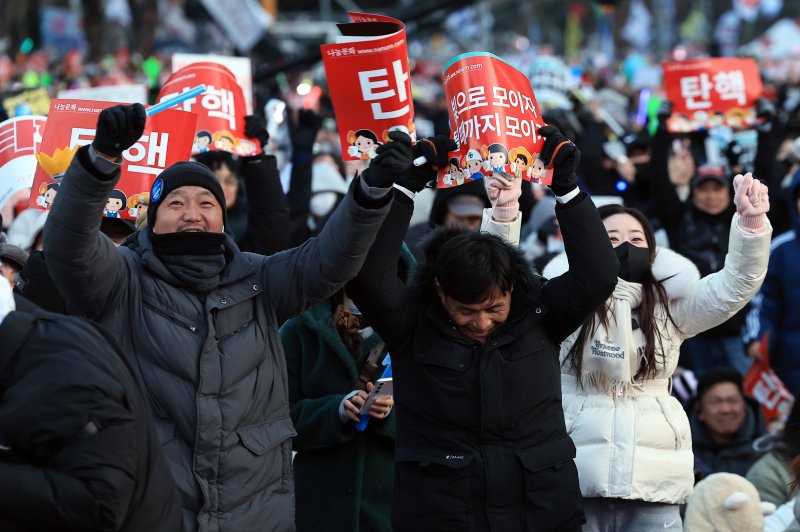 (서울=뉴스1) 박정호 기자 = 윤석열 대통령에 대한 탄핵소추안이 가결된 14일 오후 서울 여의도 국회의사당 앞에서 열린 윤석열 즉각 탄핵 범국민 촛불대행진에 참여한 시민들이 환호하고 있다. 2024.12.14/뉴스1 /사진=뉴스1화상