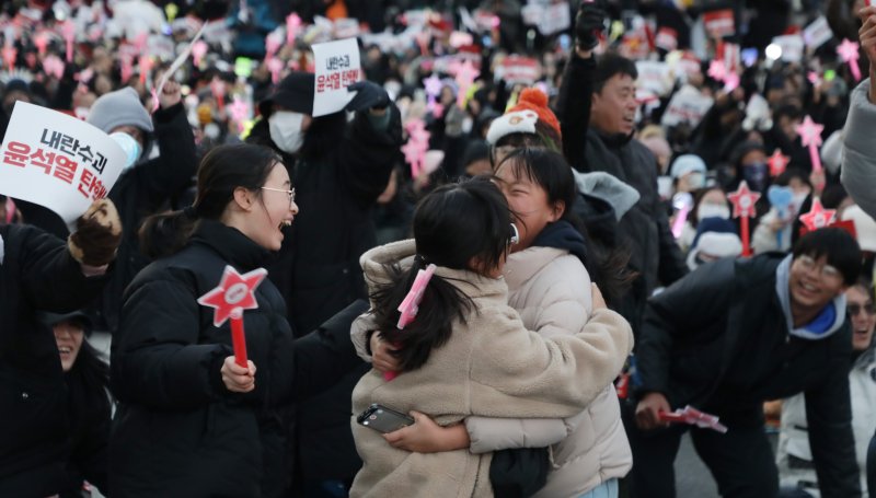 14일 '12·3비상계엄사태' 여파로 윤석열 대통령의 2차 탄핵소추안이 가결되자, 울산 남구 롯데백화점 앞에서 이를 지켜보던 시민이 서로를 안으며 기쁨을 만끽하고 있다.2024.12.14/뉴스1 ⓒNews1 김지혜 기자