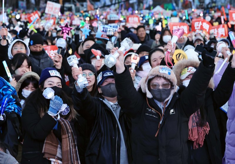 윤석열 대통령에 대한 탄핵소추안이 가결된 14일 오후 서울 여의도 국회의사당 앞에서 열린 윤석열 즉각 탄핵 범국민 촛불대행진에 참여한 시민들이 환호하고 있다. 2024.12.14/뉴스1 ⓒ News1 박정호 기자