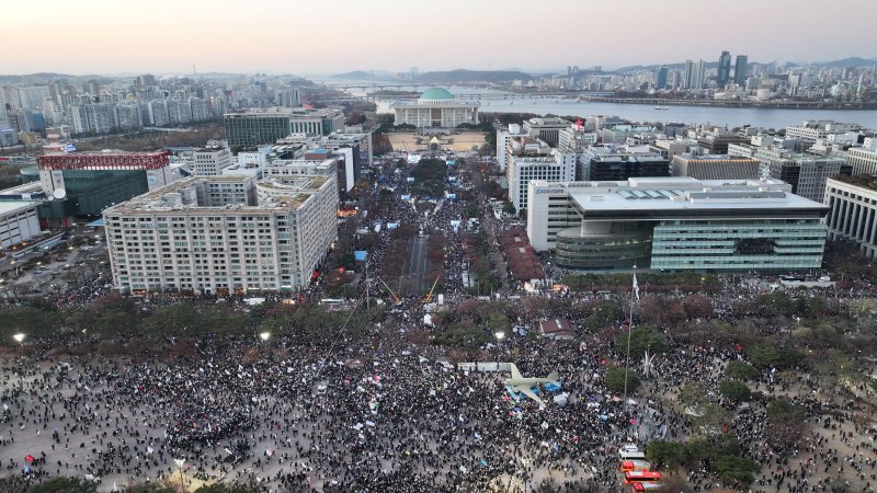 윤석열 대통령에 대한 국회 탄핵소추안이 가결된 14일 서울 여의도 국회의사당 앞에서 열린 촛불집회에서 시민들이 대통령 퇴진을 촉구하고 있다. 뉴시스