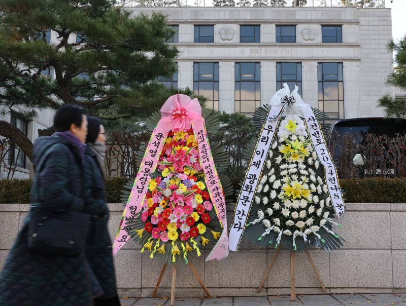 15일 서울 종로구 헌법재판소 앞에 윤석열 대통령 응원 화환과 탄핵 촉구 화환이 나란히 놓여 있다. 뉴스1